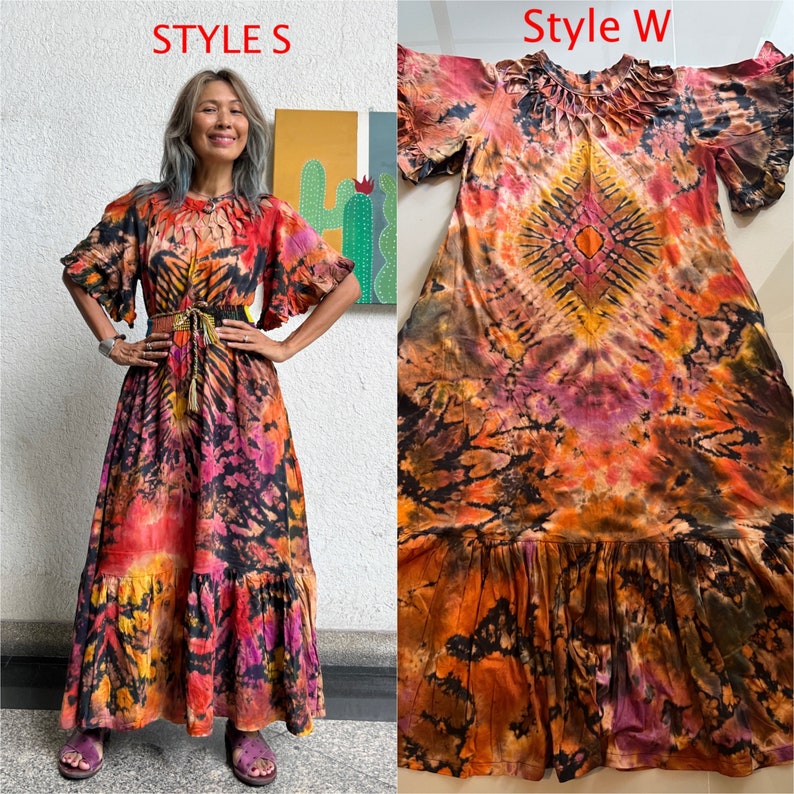 May include: Two tie-dye maxi dresses in different patterns. The dress on the left has a black, orange, and pink pattern with a ruffled hem. The dress on the right has a black, orange, and purple pattern with a ruffled hem. Both dresses have short sleeves.
