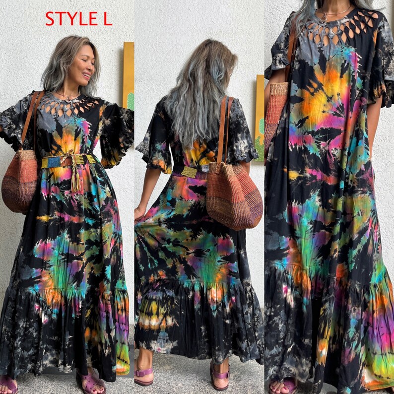 May include: A long, flowy, black tie-dye dress with a ruffled hem and a cut-out detail at the neckline. The dress has a belt and is paired with a woven tote bag.