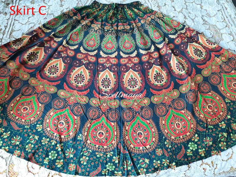 Pu&ograve; includere: Una lunga gonna nera fluida con un motivo mandala colorato. La gonna ha una cintura larga e una forma circolare fluida. Il motivo mandala presenta dettagli intricati in tonalit&agrave; di rosso, arancione, verde e blu.