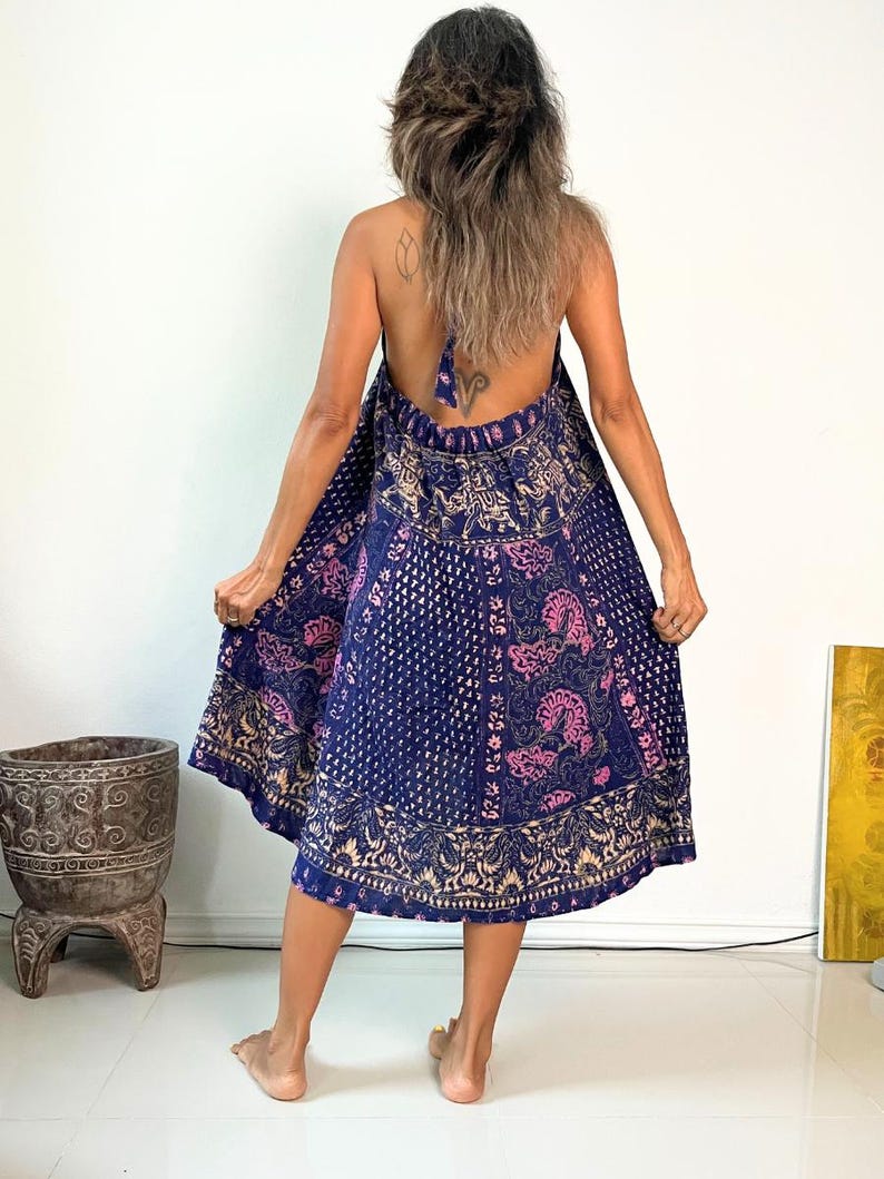 May include: A blue and pink patterned halter dress with a tie back. The dress is made of a soft, flowing fabric and has a relaxed fit.