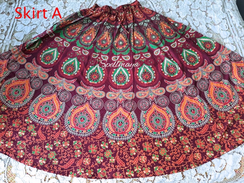 Pu&ograve; includere: Una gonna di colore marrone rossiccio con un design a mandala in rosso, arancione, verde e bianco. La gonna &egrave; realizzata in cotone e ha una vita con coulisse.