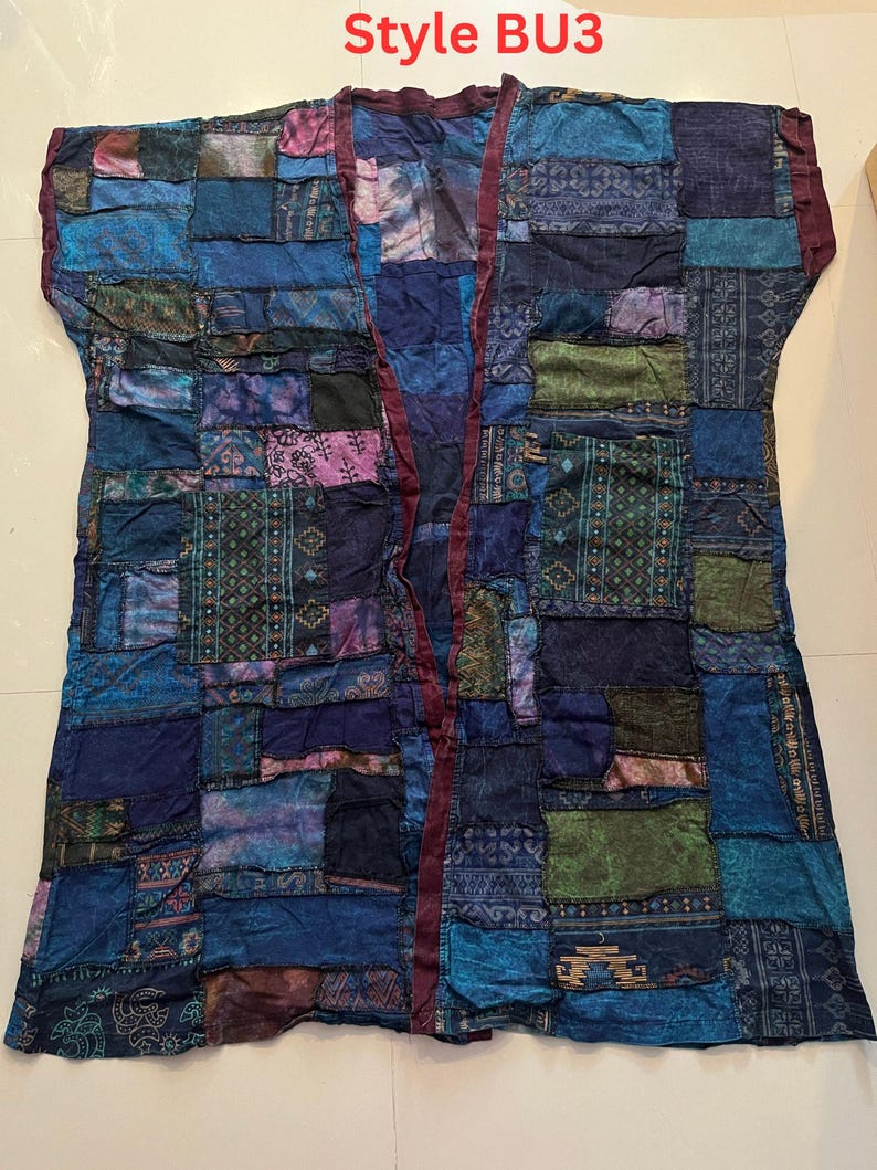 May include: A sleeveless open-front vest featuring a patchwork design composed of various blue, purple, and green fabric squares with diverse patterns. The garment includes a dark maroon trim along the front edges and displays the text Style BU3.