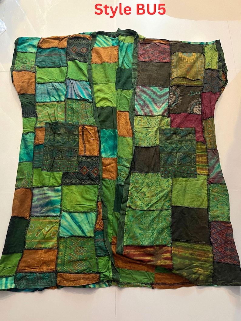 May include: A patchwork kimono-style jacket featuring various shades of green, brown, and teal fabric squares with diverse patterns and textures. The garment includes two front pockets and the text Style BU5 printed at the top center.