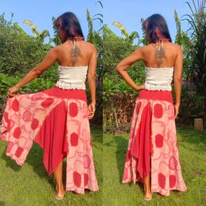 May include: A red and white tie-dye maxi skirt with a high-low hemline. The skirt is made of a lightweight fabric and has a relaxed fit.