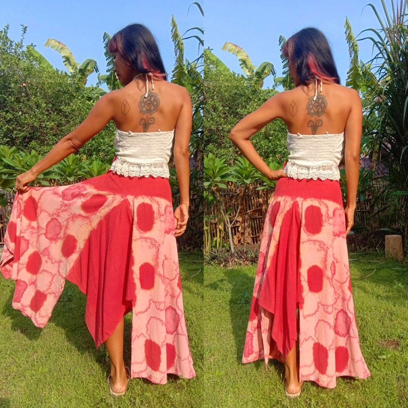 May include: A red and white tie-dye maxi skirt with a high-low hemline. The skirt is made of a lightweight fabric and has a relaxed fit.