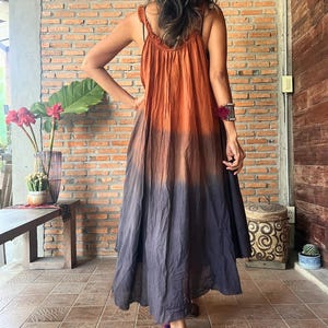 May include: A long, flowing dress with a gradient color scheme, transitioning from orange at the top to dark gray at the bottom. The dress features a crochet strap detail and is labeled "Dress D4" in the upper left corner.