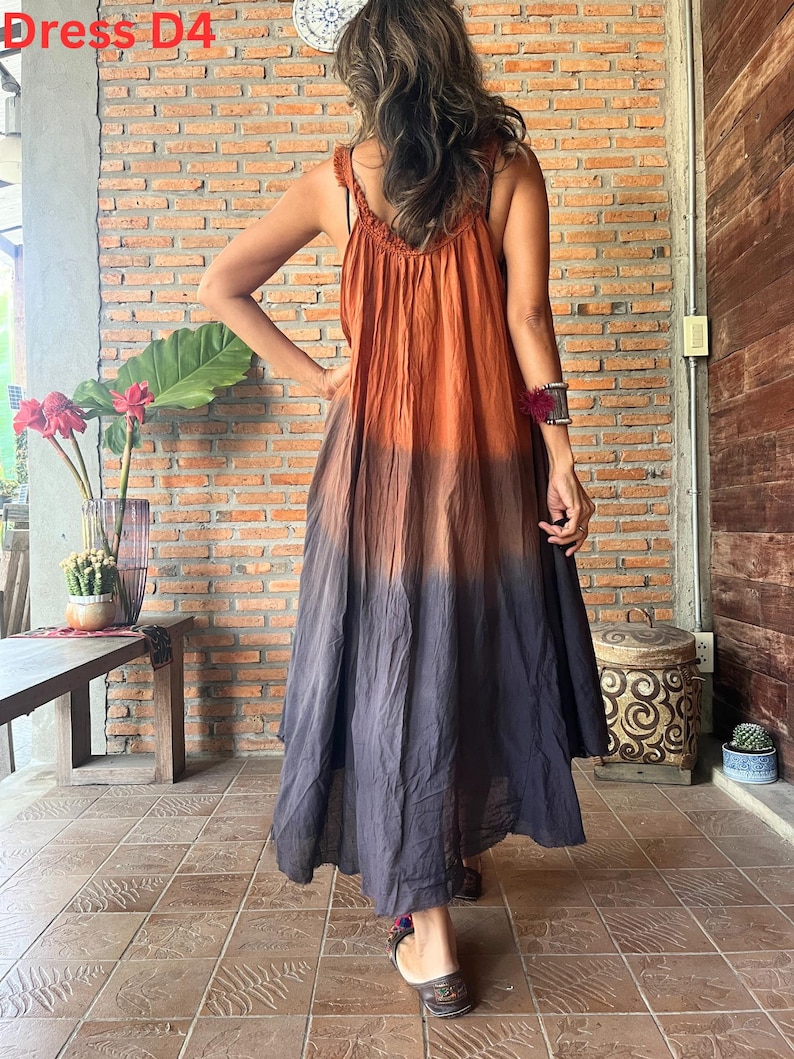 May include: A long, flowing dress with a gradient color scheme, transitioning from orange at the top to dark gray at the bottom. The dress features a crochet strap detail and is labeled "Dress D4" in the upper left corner.
