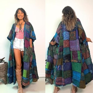 May include: A long, open-front kimono-style robe featuring a patchwork design of various fabric squares in shades of blue, green, purple, and brown. The garment has wide sleeves, a loose fit, and visible stitching throughout the multi-patterned textile.