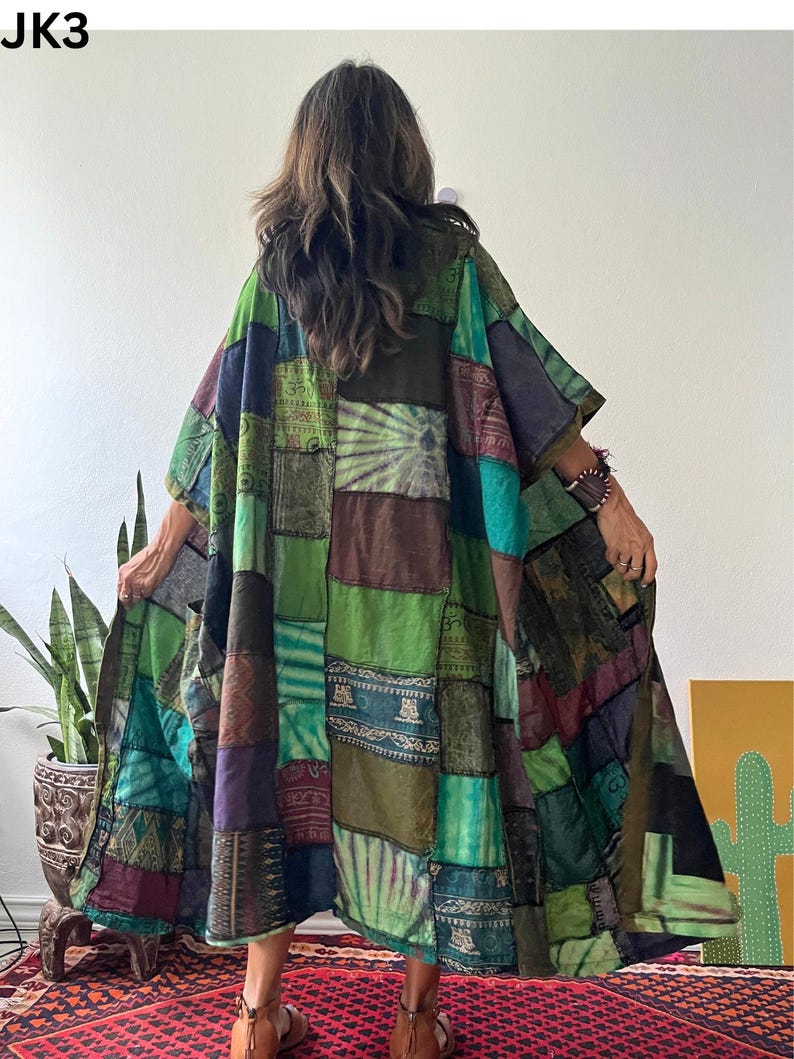 May include: A loose-fitting, long-sleeved patchwork kimono-style robe featuring a variety of green, blue, brown, and purple fabric panels with diverse patterns, including tie-dye, geometric prints, and Om symbols. The garment is labeled JK3.