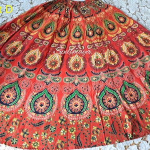 Pu&ograve; includere: Una gonna rossa, verde e gialla con un motivo a mandala. La gonna &egrave; in cotone e ha uno stile fluido e boh&eacute;mien.