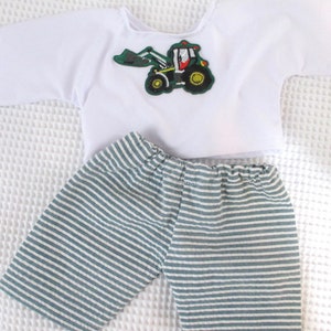 May include: A white short-sleeved shirt with a green and yellow tractor applique. The shirt is paired with blue and white striped shorts.