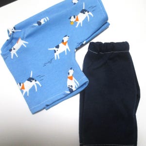 May include: A blue and white patterned shirt with a dog design and a pair of dark blue pants.