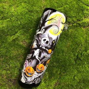 Puede incluir: Un vaso negro y blanco con un dise&ntilde;o de Pesadilla Antes de Navidad. El dise&ntilde;o presenta a Jack Skellington, Sally y otros personajes de la pel&iacute;cula. El vaso tambi&eacute;n tiene una luna amarilla con un dise&ntilde;o en espiral y el texto "Chewy Tart".