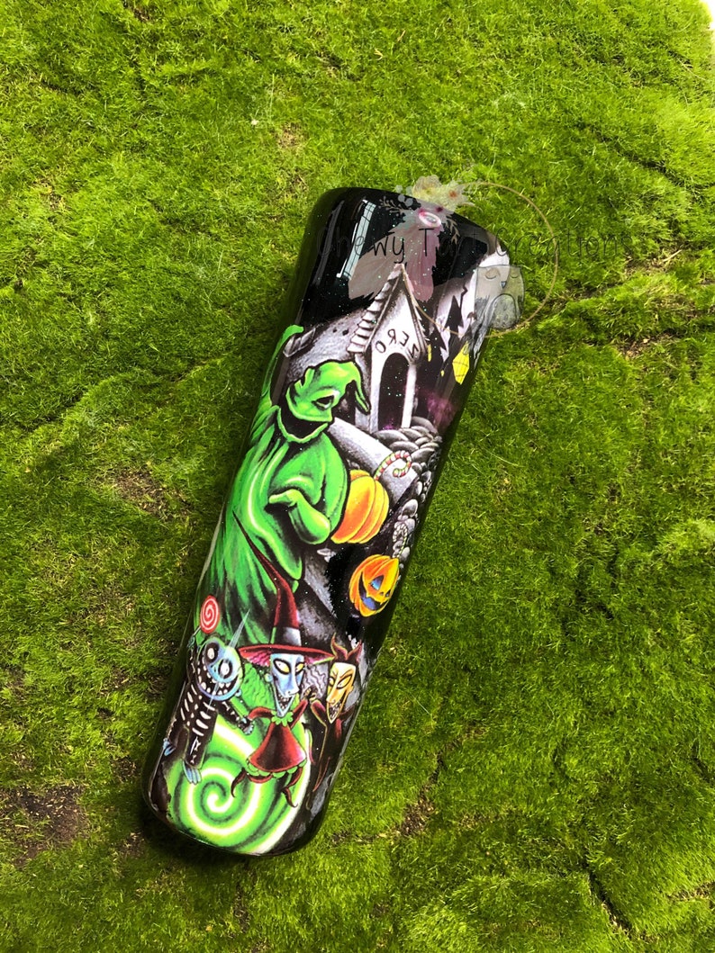 Puede incluir: Un vaso de acero inoxidable negro y verde con un estampado gr&aacute;fico de personajes de Pesadilla antes de Navidad. Los personajes incluyen a Jack Skellington, Sally y Oogie Boogie. El vaso tiene un fondo negro con un dise&ntilde;o de remolino verde.