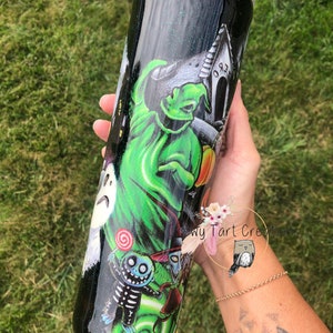 Puede incluir: Un vaso de acero inoxidable negro y verde con acabado brillante. El vaso presenta un gr&aacute;fico de personajes de Pesadilla antes de Navidad, incluyendo a Jack Skellington, Sally y el Fantasma de las Navidades Presentes. El texto "Chewy Tart Creations" es visible en el vaso.