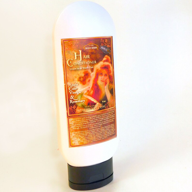 May include: A white bottle of hair conditioner with a vintage-style label featuring a woman with red hair. The label reads "Hair Conditioner, Leave in or Wash Out, Apple Cider Vinegar & Rosemary".