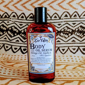 May include: A 4 oz bottle of Zir Yabs Body Oil Serum with Borage Oil, Jojoba & Olive Squalane. The bottle is amber glass with a black cap and a white label with a custom scent.