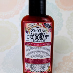 May include: A 2 fl oz travel-sized bottle of Zir Yab's Body Brew Deodorant in the scent Flower Garden. The bottle is brown glass with a black cap and a white label with floral illustrations. The label states that the product is vegan, aluminium-free, and certified New Mexico grown. The ingredients and directions for use are listed on the back of the bottle.