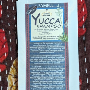 May include: A white sample packet for Zir Yabs Body Brew Yucca Shampoo. The packet features a green and red design with a drawing of a yucca plant. The text on the packet reads "Zir Yabs Body Brew Yucca Shampoo" and lists the ingredients.