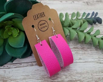 May include: A pair of pink leather earrings with silver hooks. The earrings are handmade and are labeled "Leather Handmade Just for You".