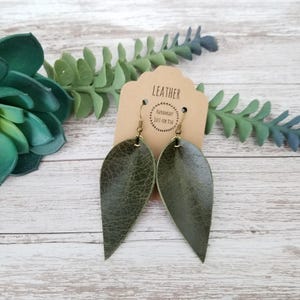 Pode incluir: Uma bandeja de servir de madeira feita à mão com acabamento natural. A bandeja retangular tem bordas elevadas e duas alças recortadas. O grão da madeira é visível. Dimensões: aprox. 40 cm de comprimento e 25 cm de largura.