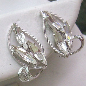 May include: Silver tone clip-on earrings with a leaf design and clear rhinestones.