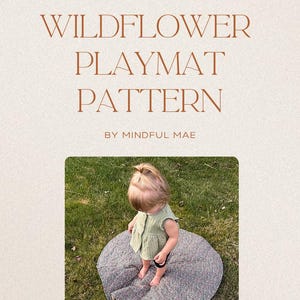 May include: A PDF pattern for a Wildflower Playmat, with a child sitting on it. The playmat is round, with a floral pattern. The text on the image reads "WILDFLOWER PLAYMAT PATTERN BY MINDFUL MAE". The child is wearing a green top.