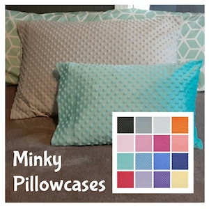 May include: Three Minky pillowcases in shades of gray and teal, with a textured dot pattern. A color chart displays various fabric options. The text "Minky Pillowcases" is displayed in white.