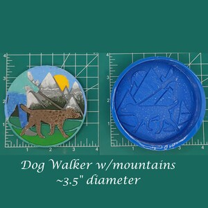 May include: A blue silicone mould for resin crafts, featuring a dog walking through a mountain landscape. The mould is approximately 3.5 inches in diameter.