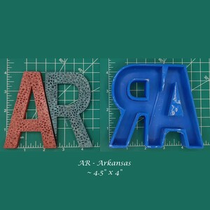 May include: Two sets of letters, "AR", made of different materials. The first set is red and textured, the second set is blue and smooth. Both sets are approximately 4.5 inches by 4 inches.