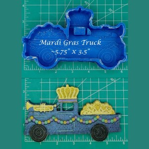 May include: A blue Mardi Gras truck mold with a crown on top. The mold is 5.75 inches by 3.5 inches.