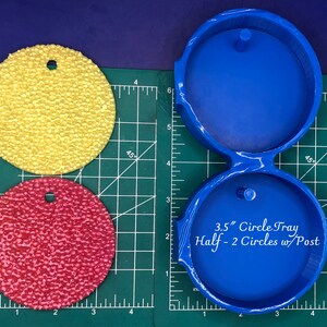 Op de afbeelding: Blauwe kunststof mal voor het maken van twee 3,5 inch halve cirkelhars ambachten. De mal heeft een pen in het midden van elke halve cirkel.
