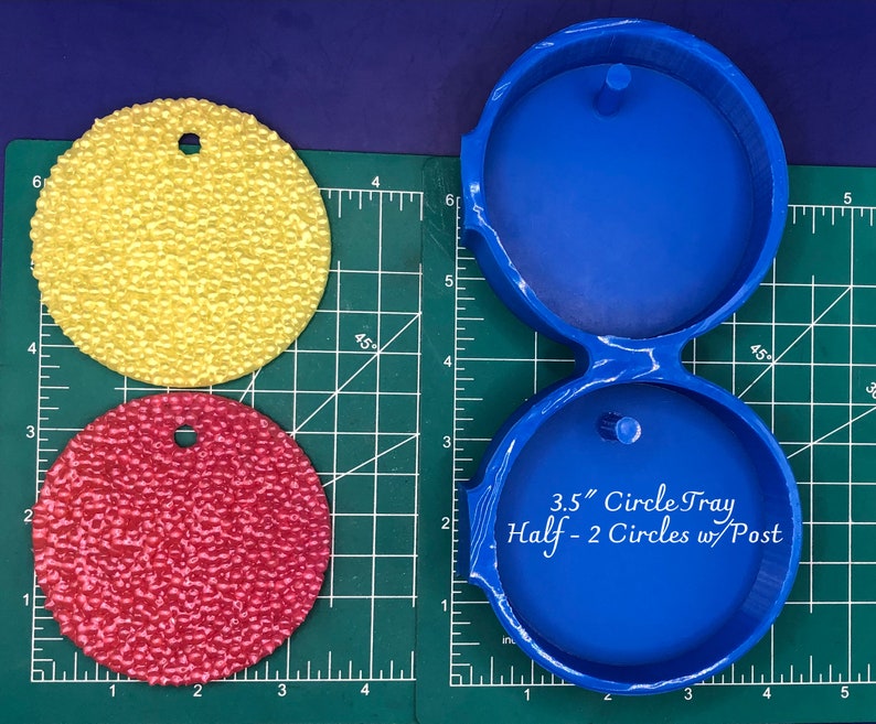 Op de afbeelding: Blauwe kunststof mal voor het maken van twee 3,5 inch halve cirkelhars ambachten. De mal heeft een pen in het midden van elke halve cirkel.