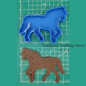 Puede incluir: Molde de plástico azul de un caballo caminando sobre una estera de corte verde con un caballo de fondant marrón sobre una estera de corte verde debajo. El texto "Tennessee Walking Horse ~ 5" x 4" está impreso en la estera.