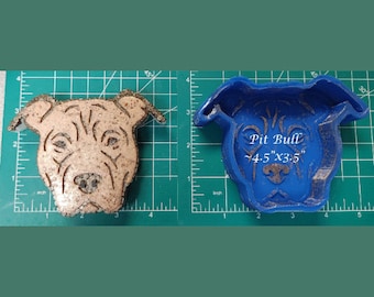 May include: A blue silicone mold of a Pit Bull dog head. The mold is 4.5 inches by 3.5 inches and has the text "Pit Bull 4.5" x 3.5" written on it.