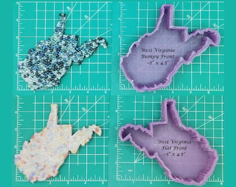 May include: Four West Virginia-shaped items are displayed. Two are filled with colorful beads, and two are purple plastic molds. The molds are labeled "West Virginia Bumpy Front" and "West Virginia Flat Front," each approximately 5 x 4.5 inches.