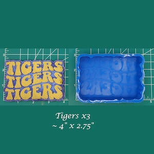 May include: A blue silicone mold for making resin crafts. The mold is shaped like the word "Tigers" repeated three times. The mold is approximately 4 inches by 2.75 inches.