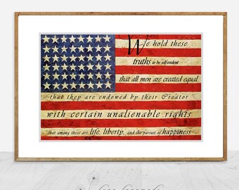 May include: Framed print of the American flag with the Declaration of Independence text. The flag features red and white stripes and a blue field with white stars. The text is in a handwritten style.