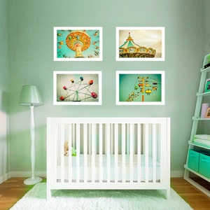 May include: Four framed prints of amusement park rides hang above a white crib in a nursery. The prints depict a carousel, Ferris wheel, swing ride, and ski lift. The room is painted a light green color.