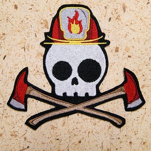 May include: A white skull wearing a red and yellow firefighter's helmet with a flame design. The skull is crossed with two brown axes with red blades.