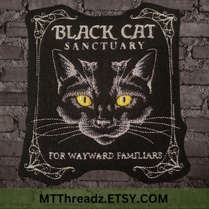 May include: Black and white embroidered patch with a black cat's face and the text "Black Cat Sanctuary for Wayward Familiars". The text "MTTthreadz.ETSY.COM" is at the bottom of the patch.
