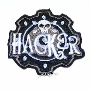 May include: Black and white embroidered patch with a gear design and the word "HACKER" in a white font. A skull with crossbones is in the center of the gear.