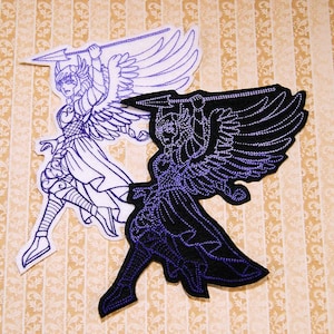 May include: Two embroidered patches of a winged figure holding a spear. One patch is white with purple stitching, the other is black with purple stitching.