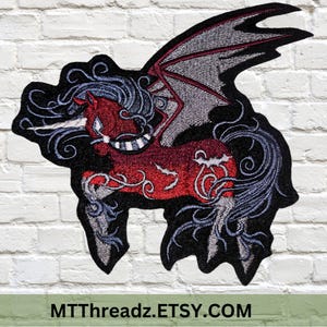 May include: Red and black embroidered patch of a winged unicorn with a white horn and blue mane. The unicorn is standing on its hind legs with its wings spread out. The patch is surrounded by a black border.