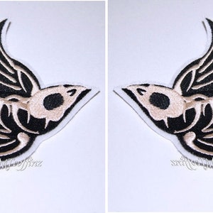 May include: Two black and white embroidered iron-on patches of a skeleton swallow bird. The bird is in flight with its wings spread out.