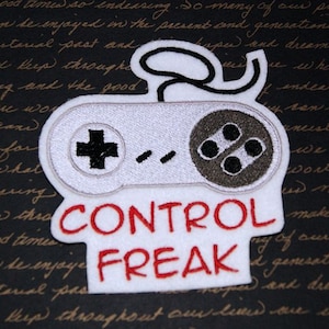 May include: White embroidered patch with a gray video game controller and the text "CONTROL FREAK" in red.