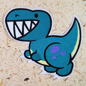 May include: A blue and yellow embroidered iron-on patch of a cartoon dinosaur with a toothy grin and purple spots.