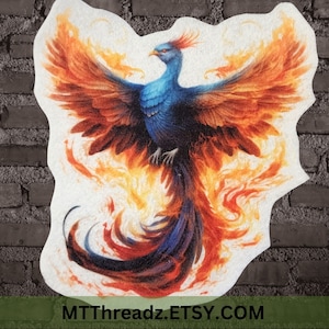 May include: A colorful phoenix with orange, red, and yellow flames rising from its tail feathers. The phoenix has blue and teal feathers on its body and a long, thin neck with a small head. The phoenix is depicted against a white background.