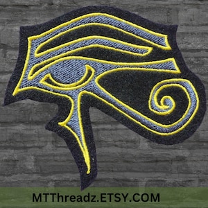 Puede incluir: Un parche bordado con el Ojo de Horus, un s&iacute;mbolo de protecci&oacute;n y poder en la mitolog&iacute;a egipcia antigua. El parche es negro con bordados amarillos y azules.