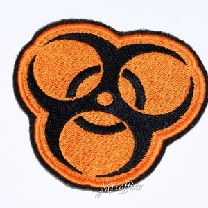 May include: Orange and black embroidered patch with a biohazard symbol.